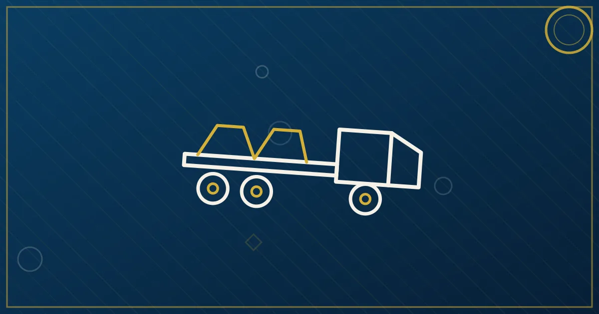 Flatbed trailer loaded with steel coils secured by chains and edge protectors on a highway